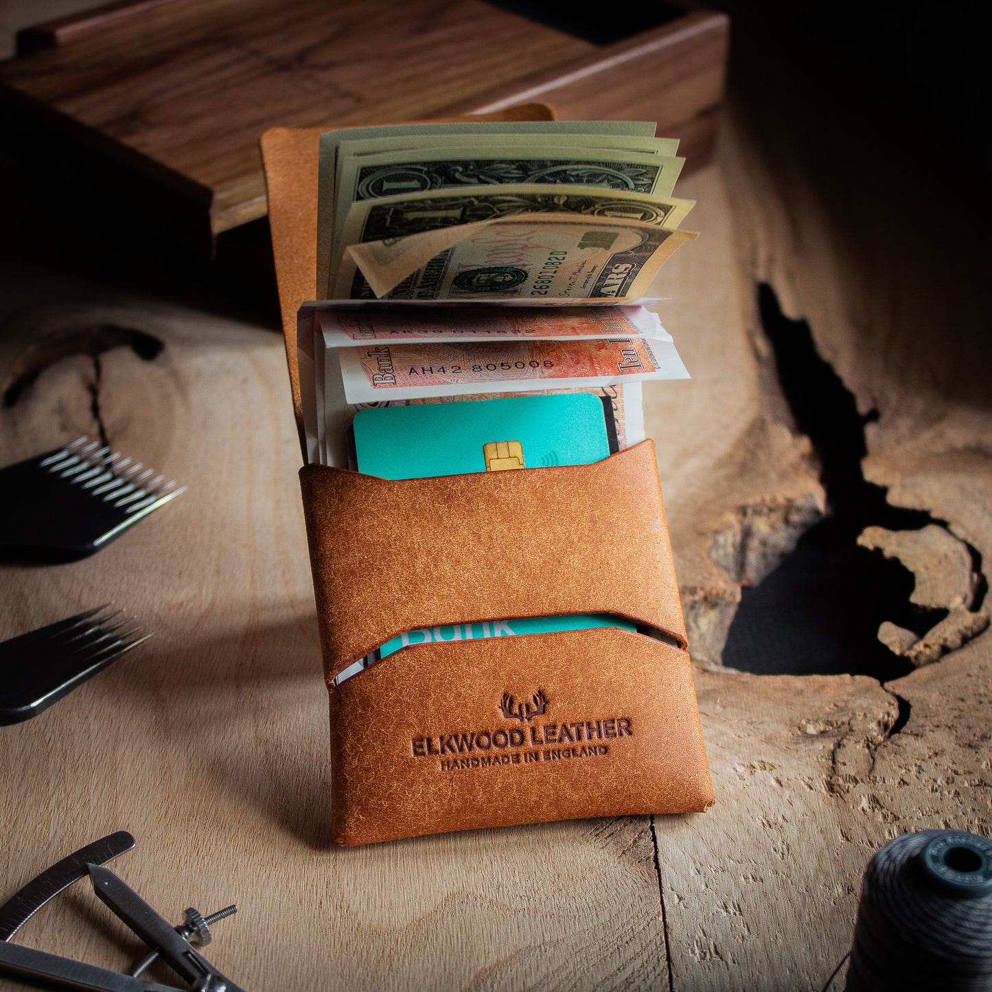 EDC Leather stitchless wallet - closed open with UK Pound and US dollar on wooden table with leathercraft tools