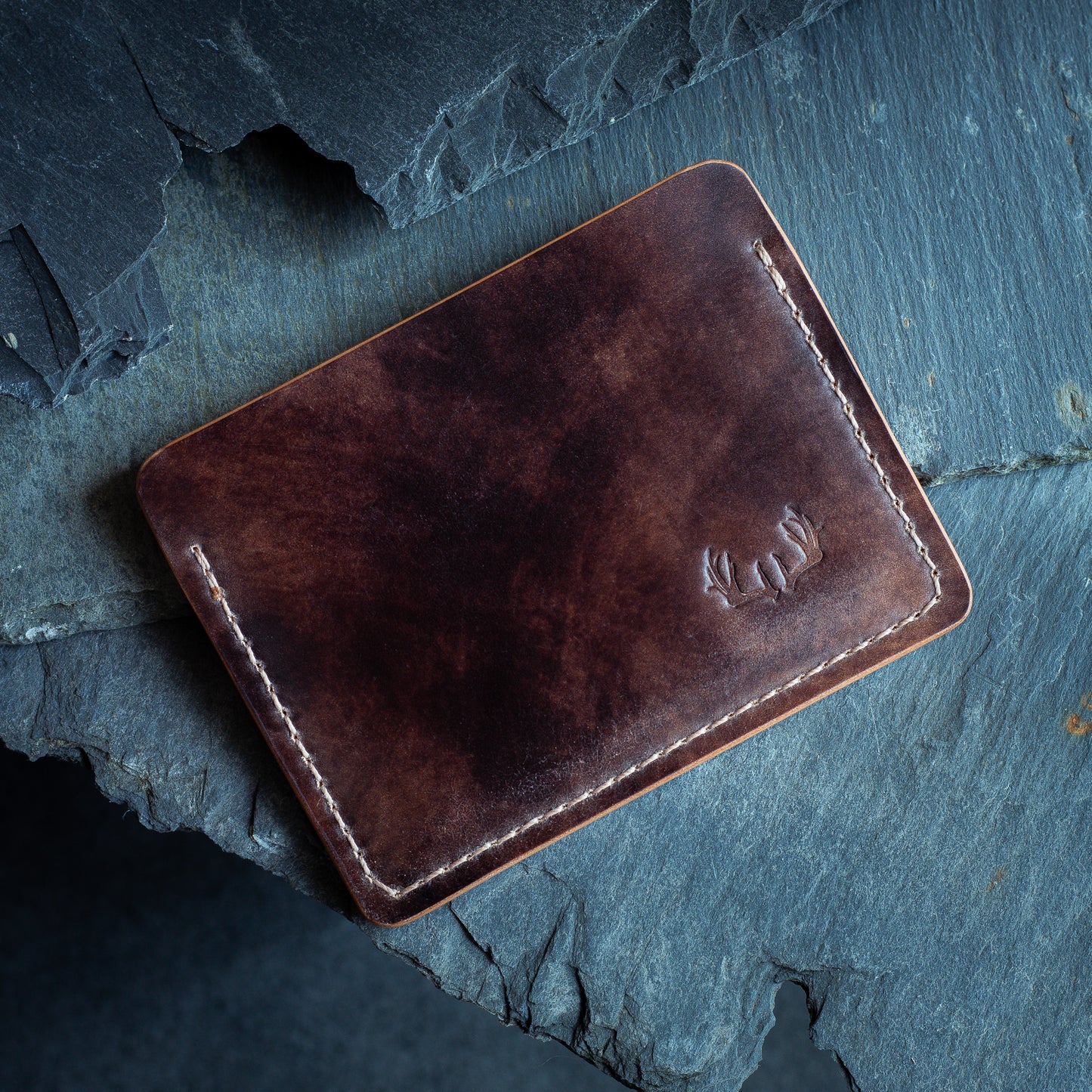 Shell cordovan leather cardholder wallet onto of slate, crafted from Rocado Brown Museum Leather