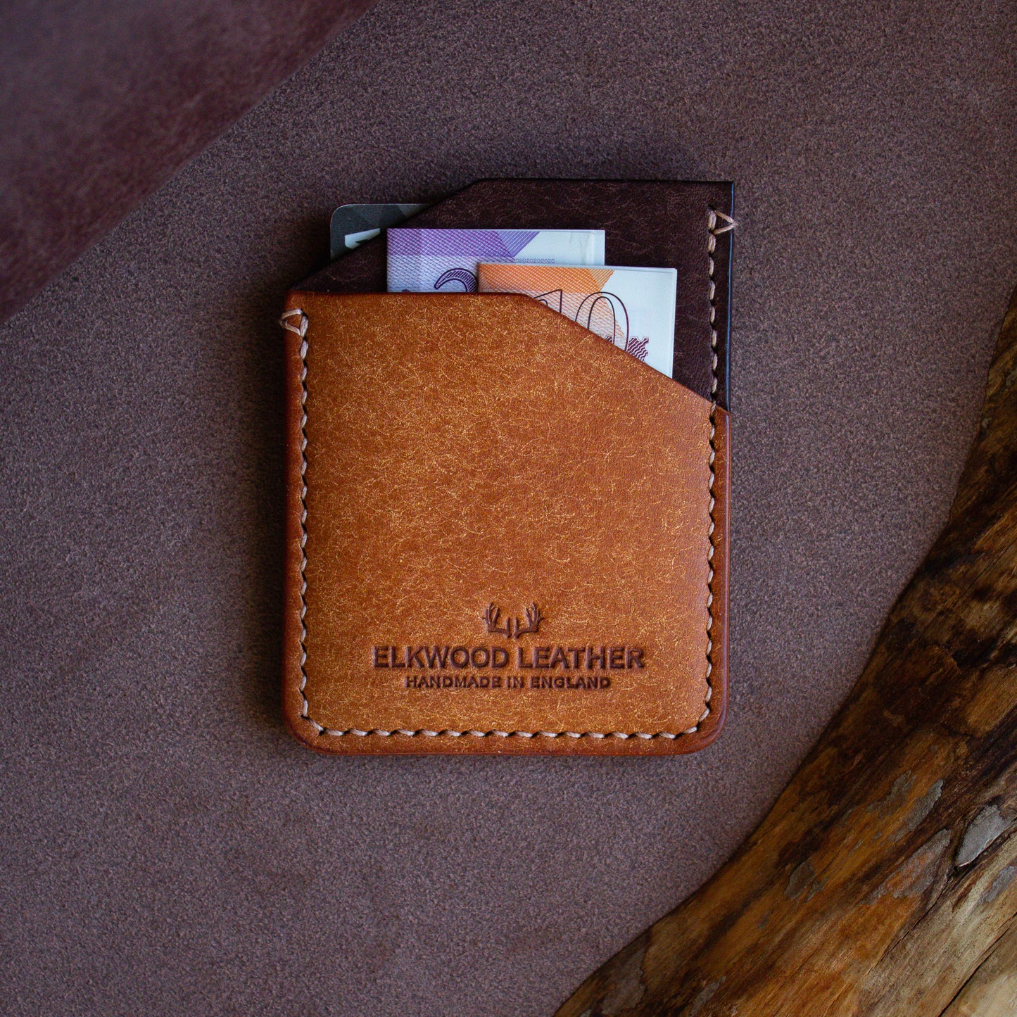 Elkwood Leather - The Maple - minimalist full grain Italian Pueblo leather cardholder wallet with credit cards and cash on roll of leather next to wood grain