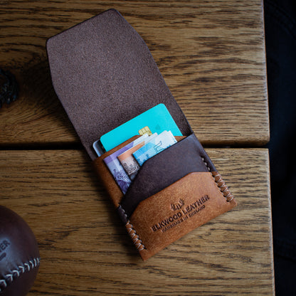 Elkwood Leather - The Blackthorn - EDC Flap full grain Italian Pueblo leather cardholder wallet open with credit cards wooden table next to brown leather baseball