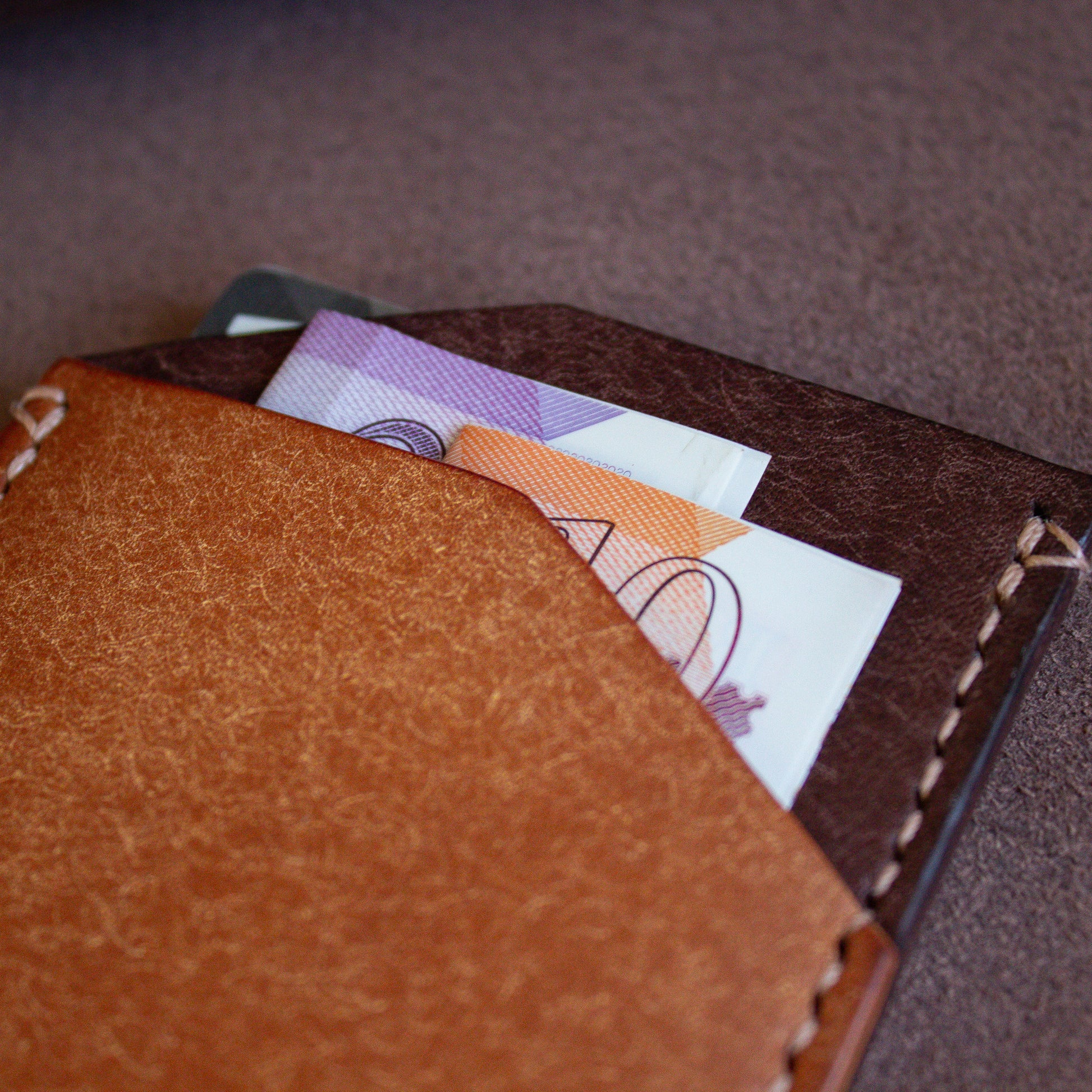 LEATHER PDF PATTERN - Elkwood Leather - The Maple - minimalist full grain Italian Pueblo leather cardholder wallet close up of pocket with cash and credit cards on roll of leather next to wood grain