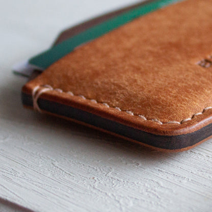 Elkwood Leather - The Aspen - minimalist full grain Italian Pueblo leather cardholder wallet on white wooden table next to galaxy pen and knife and keys close up of edges 