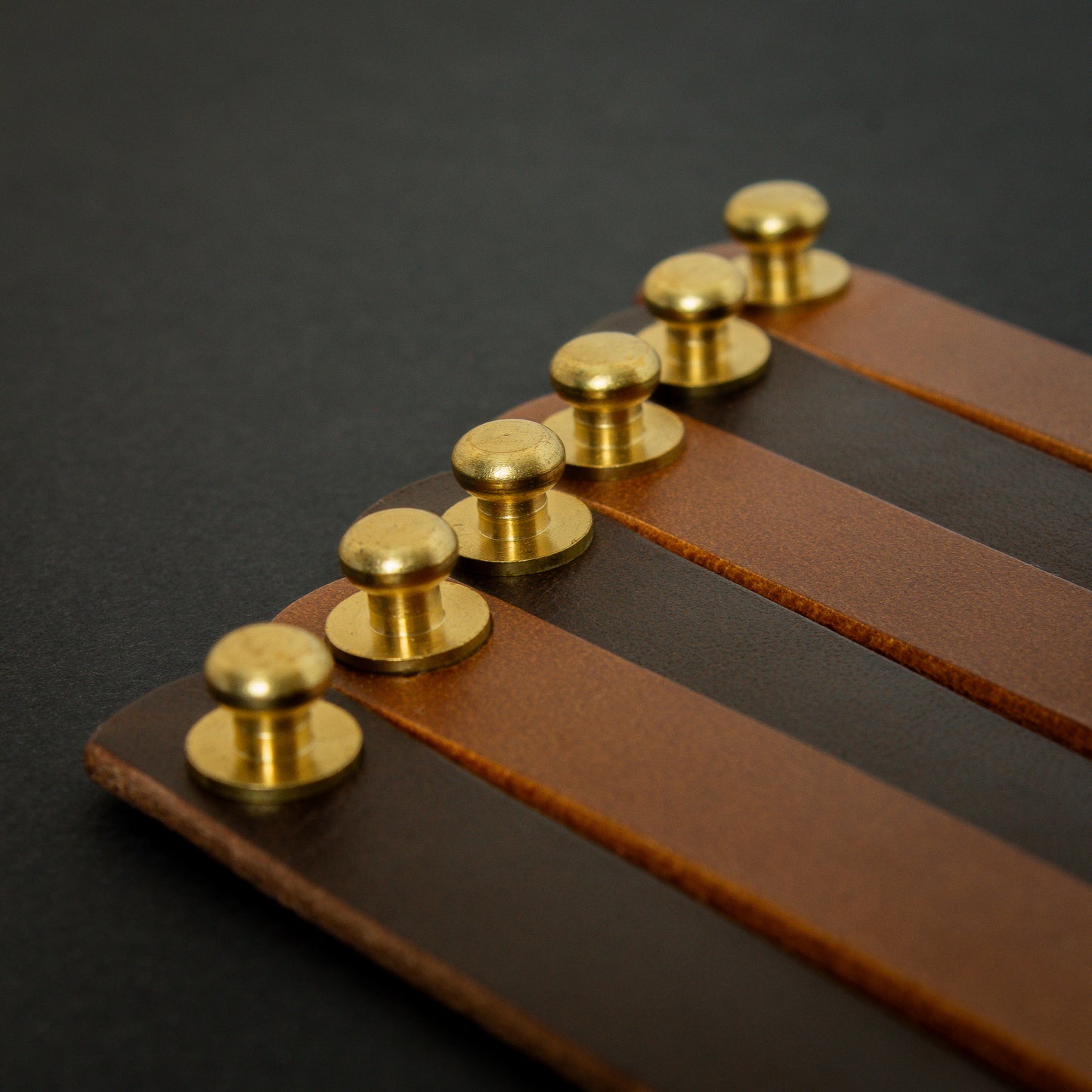 handmade leather wrist bands with solid brass sam browne studs - made from Buttero leather close up brass studs