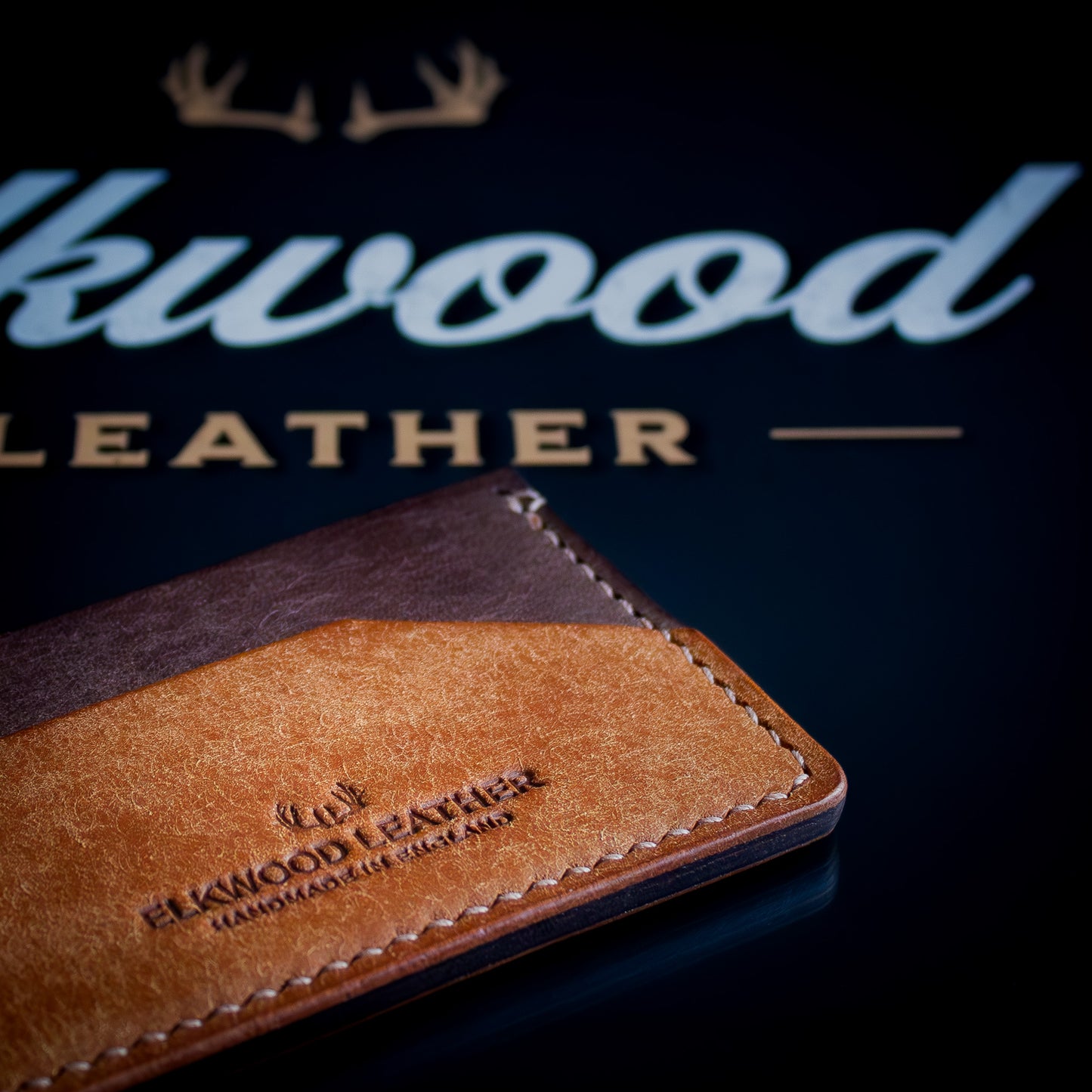 The Aspen - minimalist leather cardholder wallet on black Elkwood Leather logo close up handstitching