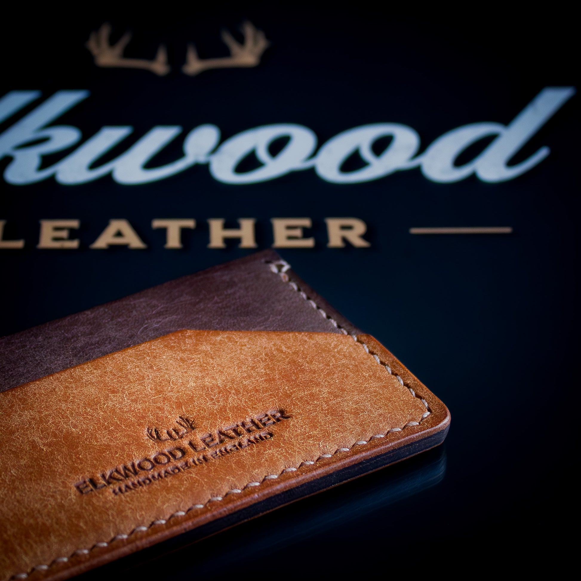 The Aspen - minimalist leather cardholder wallet on black Elkwood Leather logo close up handstitching