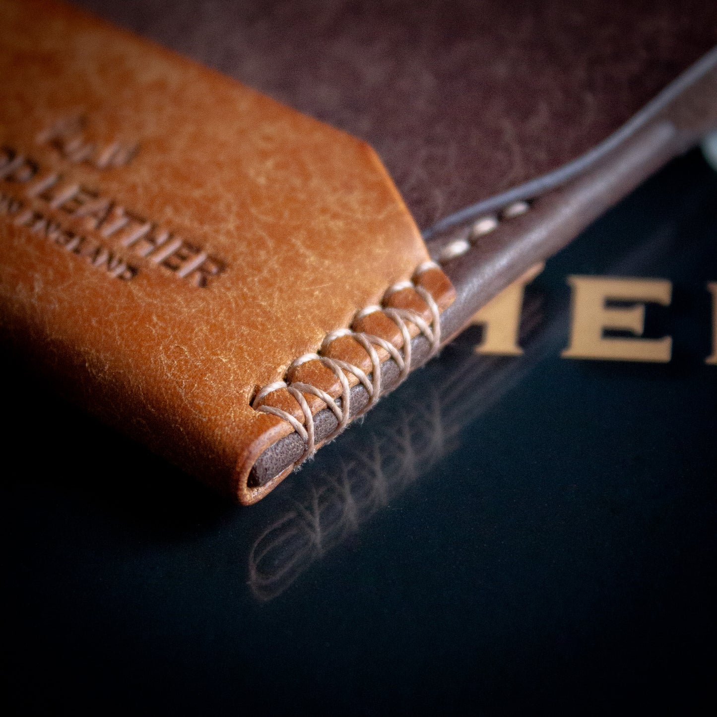 Elkwood Leather - The Blackthorn - EDC Flap full grain Italian Pueblo leather cardholder wallet open close up of pockets on wooden table next to brown leather baseball - close up saddle stitching