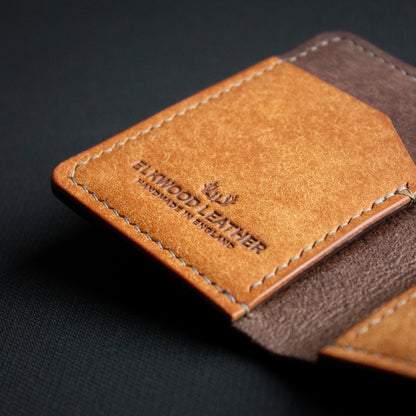 handcrafted brown leather wallet ontop of black background - open leather cardholder - Badalassi Carlo Pueblo Cognac and Castagno leather - close up saddle stich with grey xiange thread and pocket with elkwood leather logo
