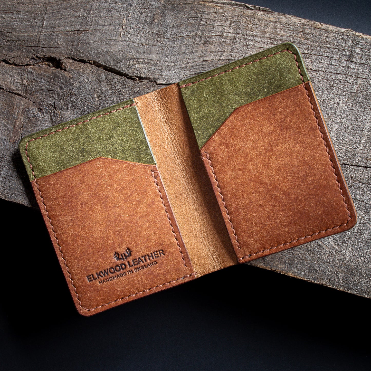 cognac and olive green leather bifold cardholder wallet open on rustic wood