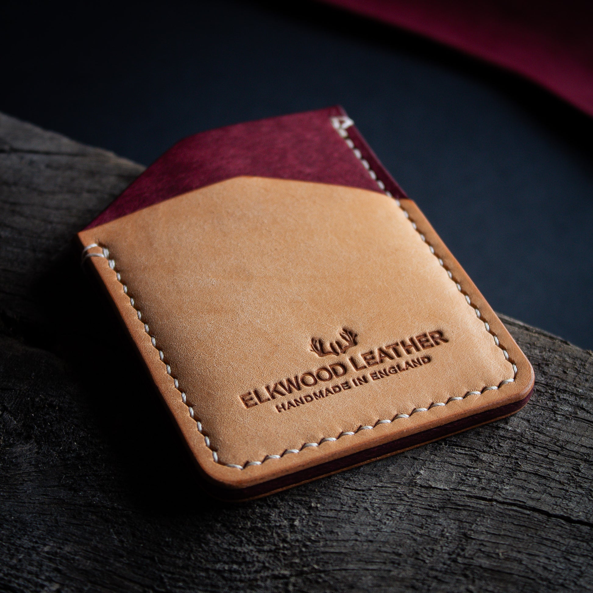 The Maple Cardholder wallet in Mosto and Bone Pueblo leather, on top of rugged wood