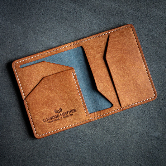 Elkwood Leather the cedar bifold wallet in Navy & Cognac Pueblo leather, on top of flesh side Nero leather hide open pockets
