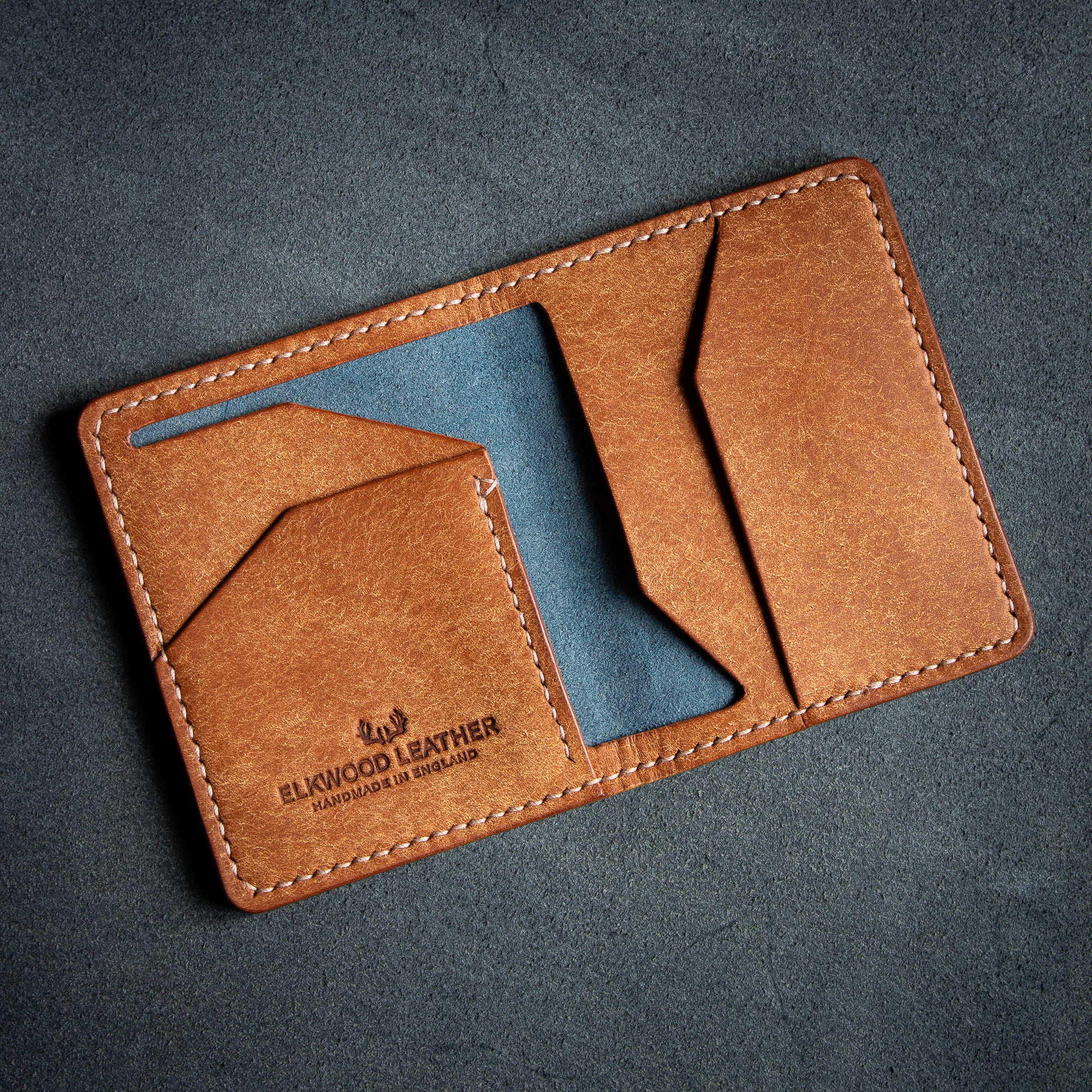 Elkwood Leather the cedar bifold wallet in Navy & Cognac Pueblo leather, on top of flesh side Nero leather hide open pockets