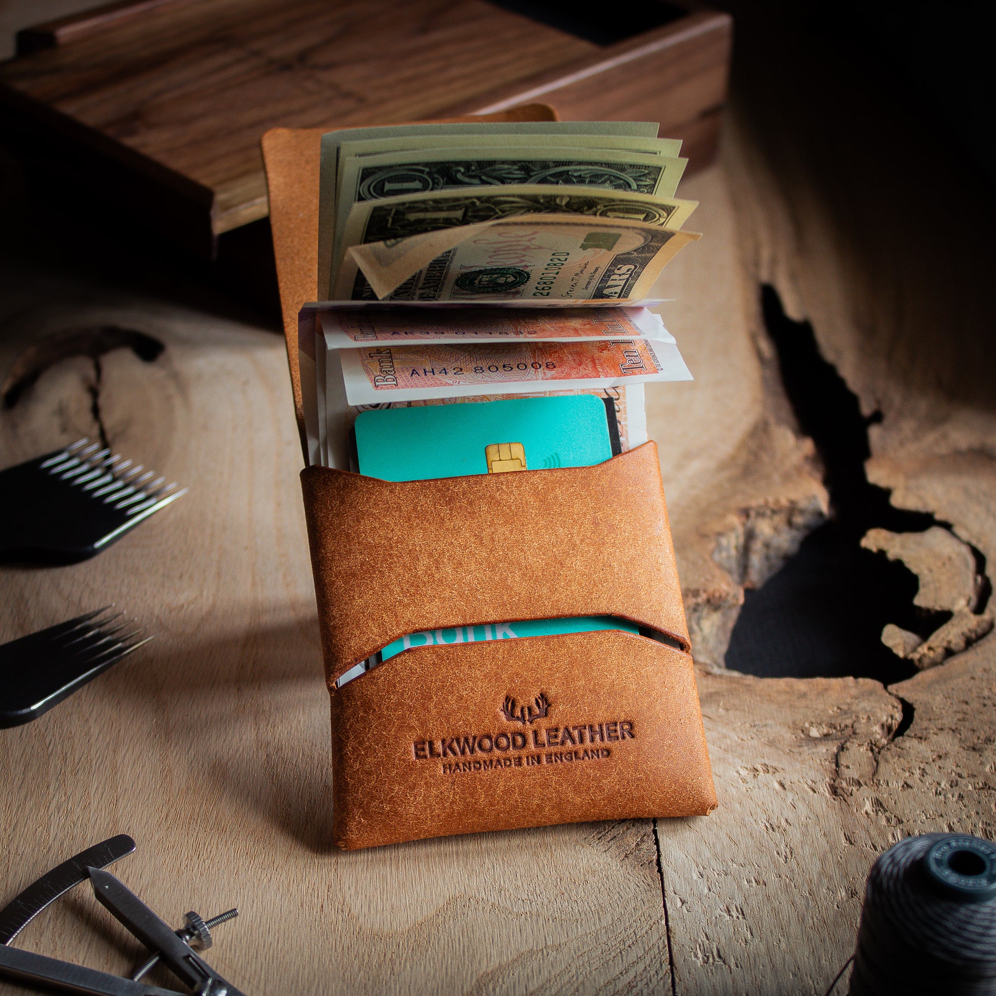 EDC Leather stitchless wallet - closed open with UK Pound and US dollar on wooden table with leathercraft tools