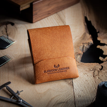 EDC Leather stitchless wallet - closed flap on wooden table with leathercraft tools