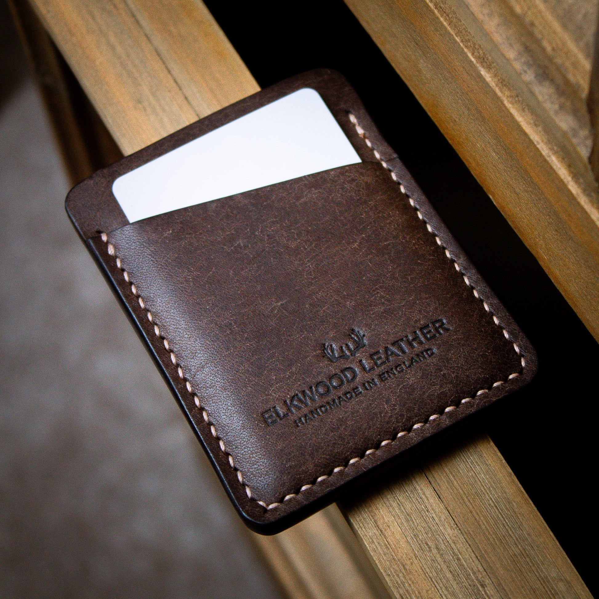 Brown leather cardholder onto of wooden dresser