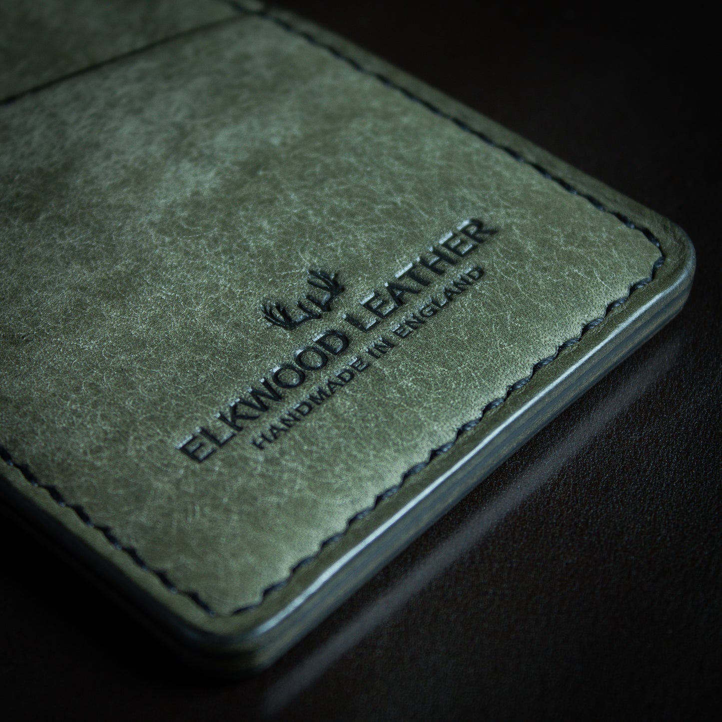 Minimalist cardholder with credit card in slot - Grigio Pueblo leather close up logo