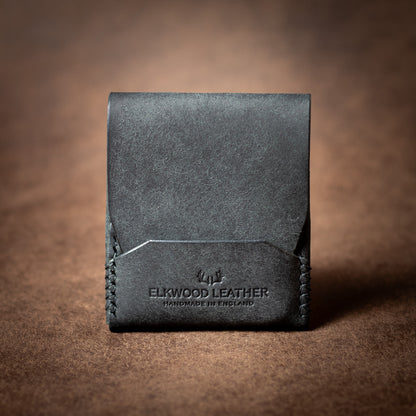 Elkwood Leather black leather EDC cardholder with black stitching on a brown leather wallet background closed