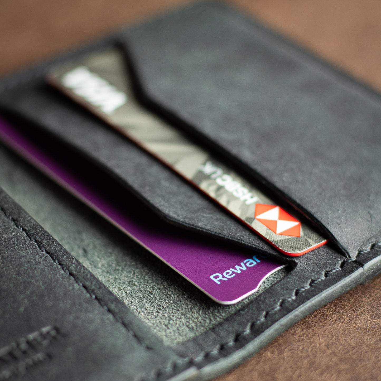 Closeup of credit cards inside a black full grain leather bifold wallet - Elkwood leather handmade 