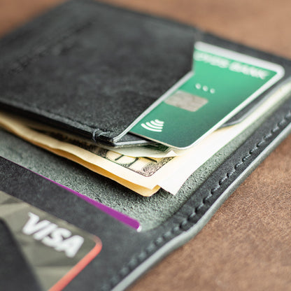 closeup of cash and cards inside a black pueblo leather bifold wallet