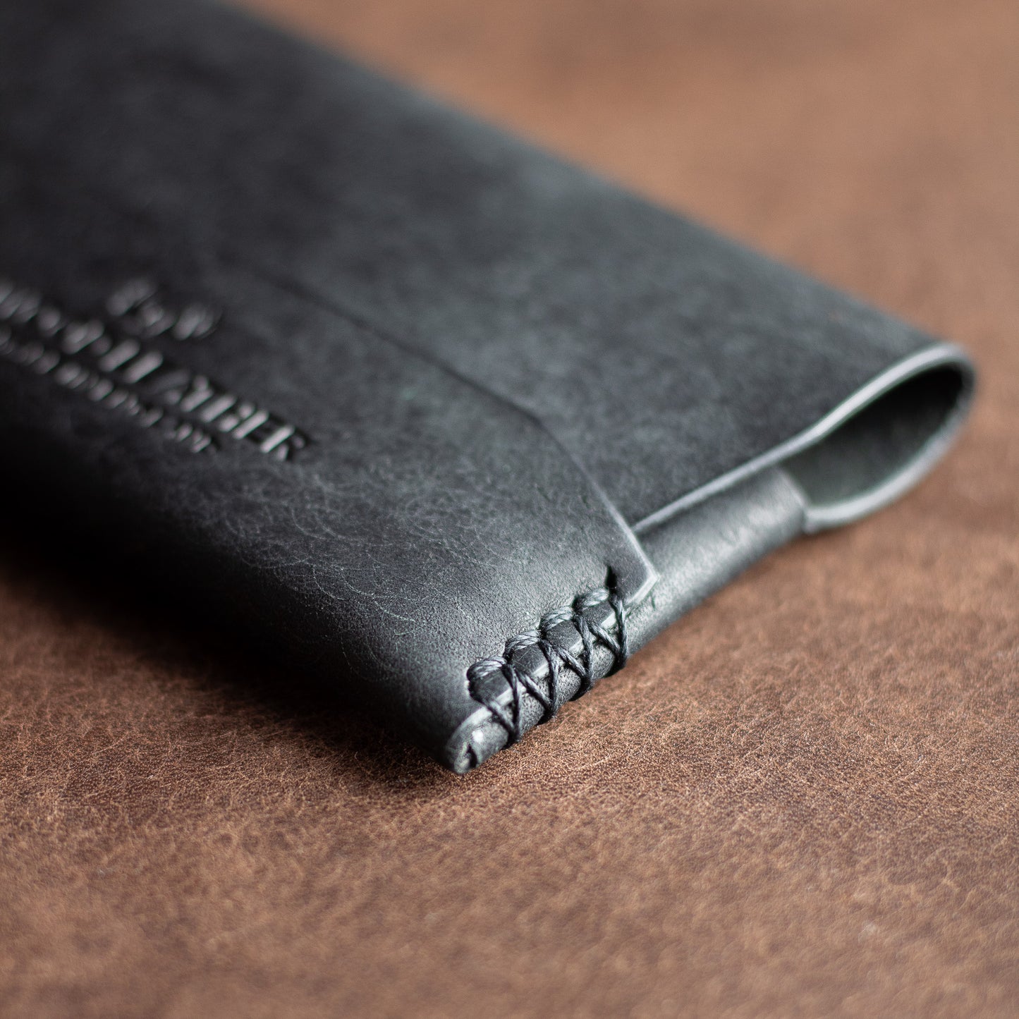 Closeup of stitching on a black Italian leather horizontal wallet 