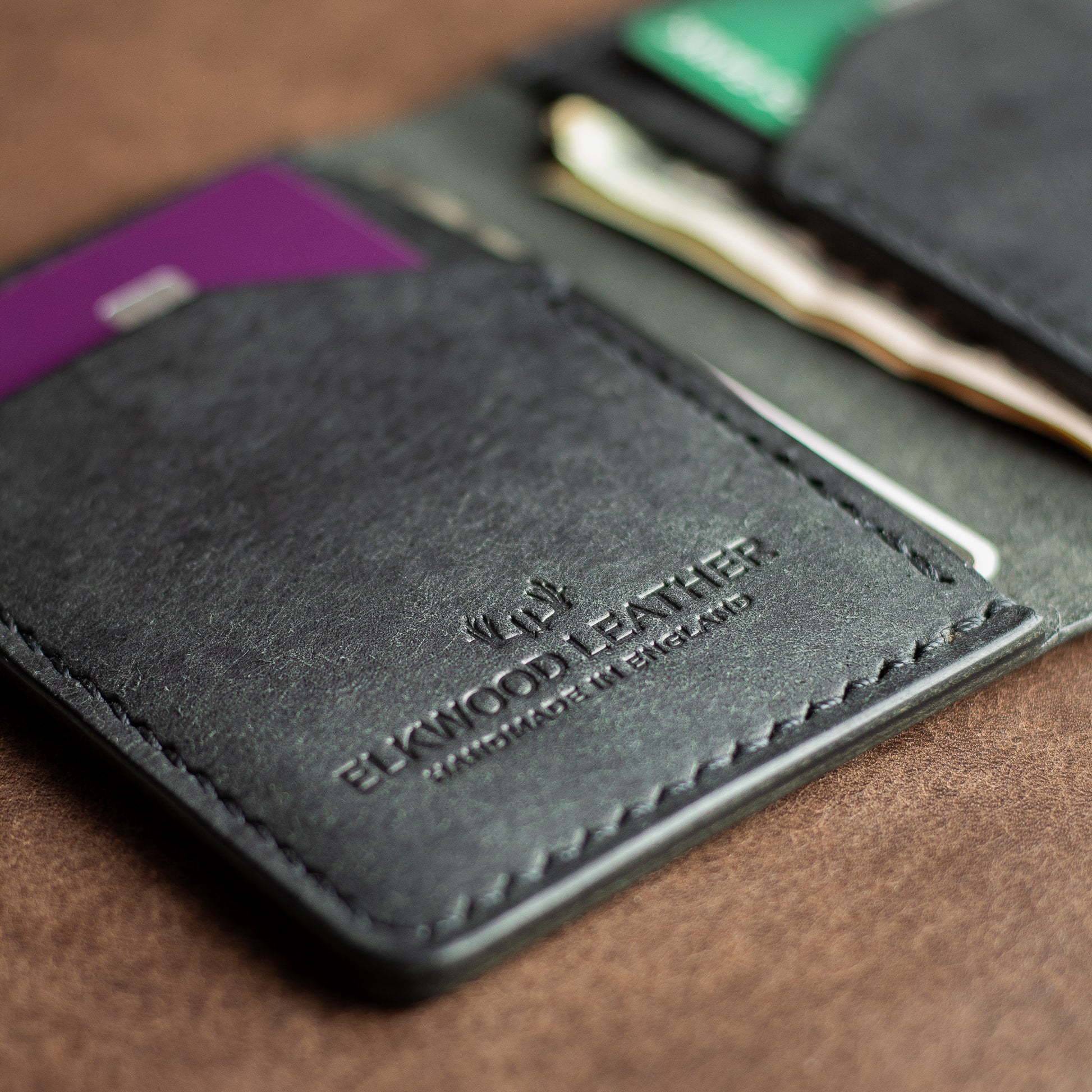 Black leather bifold wallet - Elkwood leather logo and stitching close up