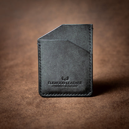 Elkwood Leather black leather cardholder wallet with black stitching on a brown leather background